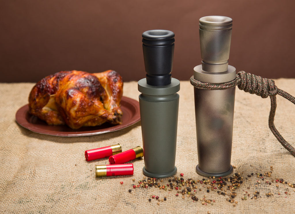 A pair of duck call style peppermills on a festive table.