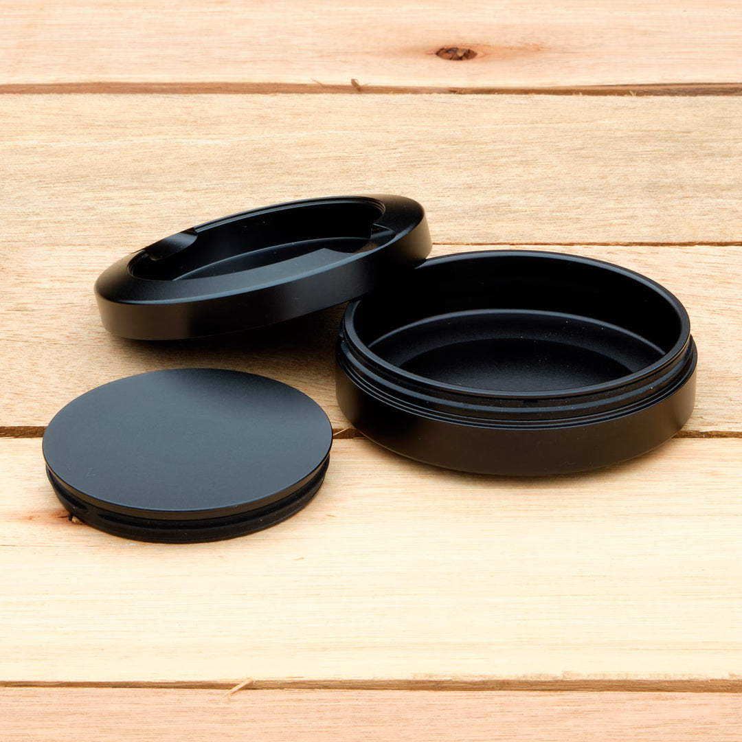 Black aluminum pouch case on a wooden surface