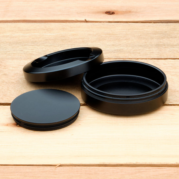 Black aluminum pouch case on a wooden surface