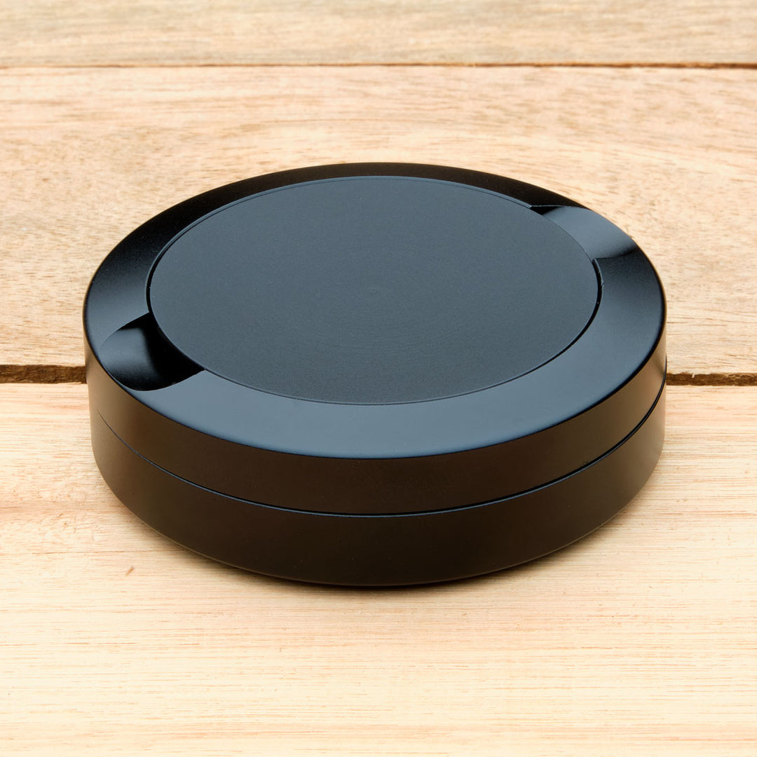 Black aluminum pouch case on a wooden surface