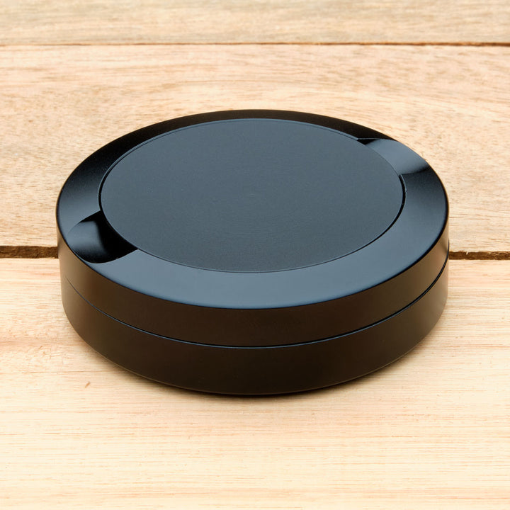 Black aluminum pouch case on a wooden surface