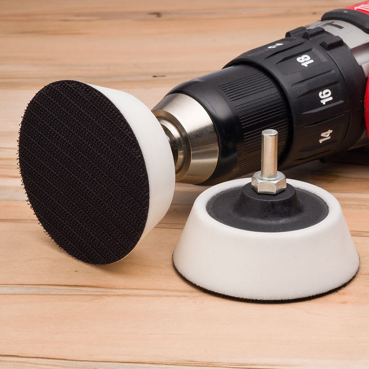 Drill with sanding disc holder on a wooden surface