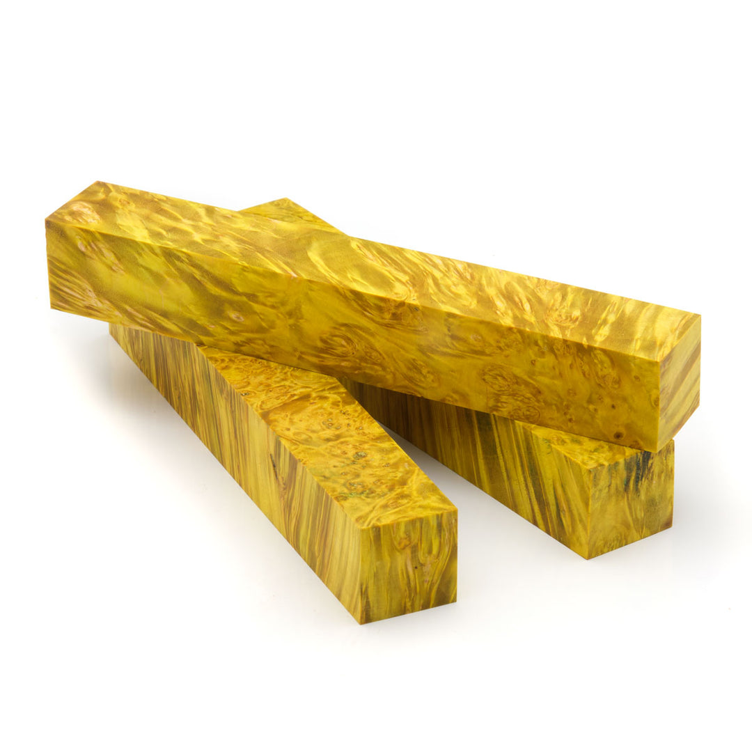 Three yellow dyed box elder burl pen blanks laying on a white background
