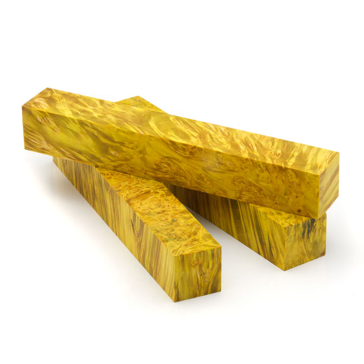 Three yellow dyed box elder burl pen blanks laying on a white background