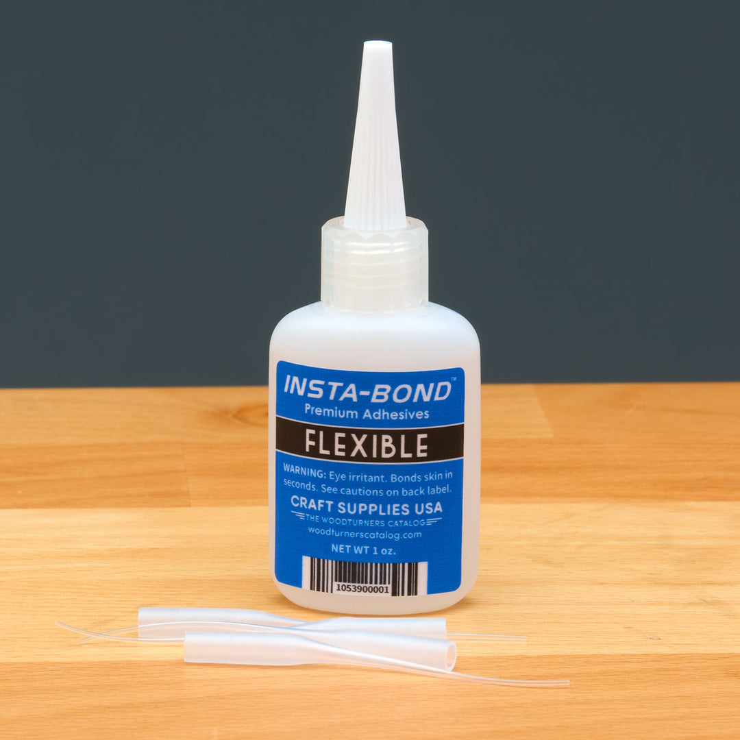 Insta-Bond adhesive bottle with applicators on a wooden surface