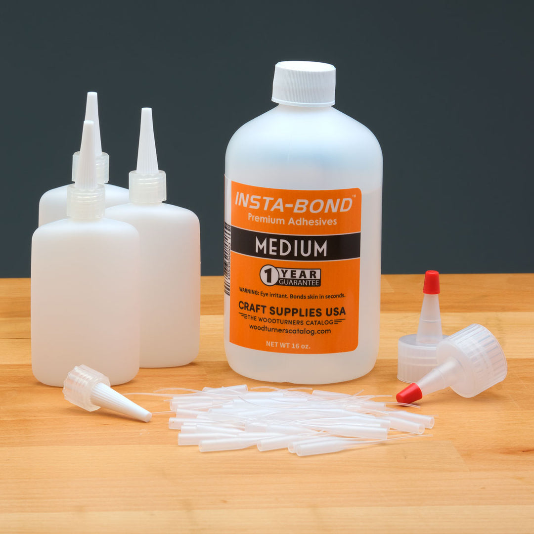 Insta-Bond adhesive bottle with applicators on a wooden surface