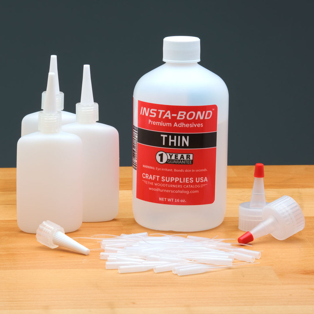 Insta-Bond Thin glue bottle with applicators on a wooden surface